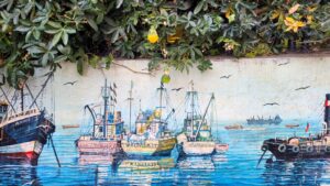 Mural of boats anchored in a port beneath a fruit plant