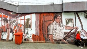 long mural of a bus driver with passengers in black and red