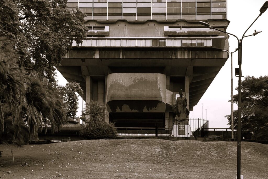 Raised concrete building dominating a field