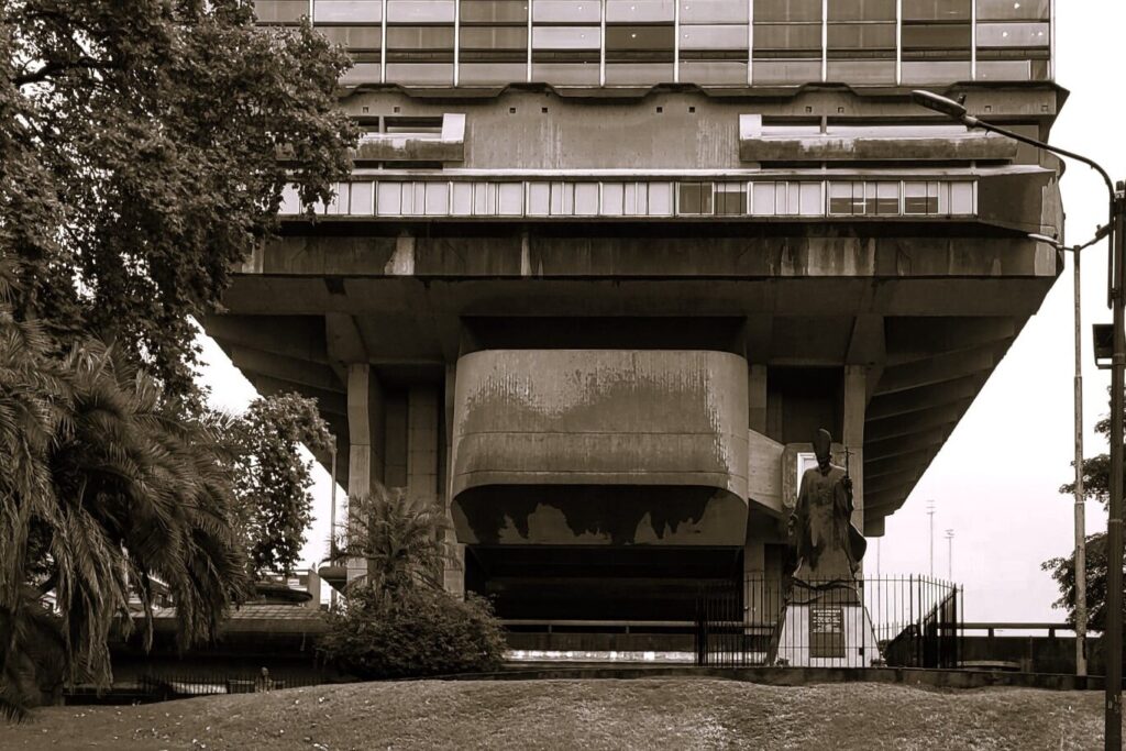 Raised concrete building dominating a field