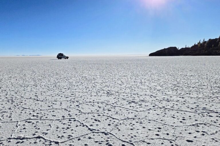 a car driving on a flat white surface